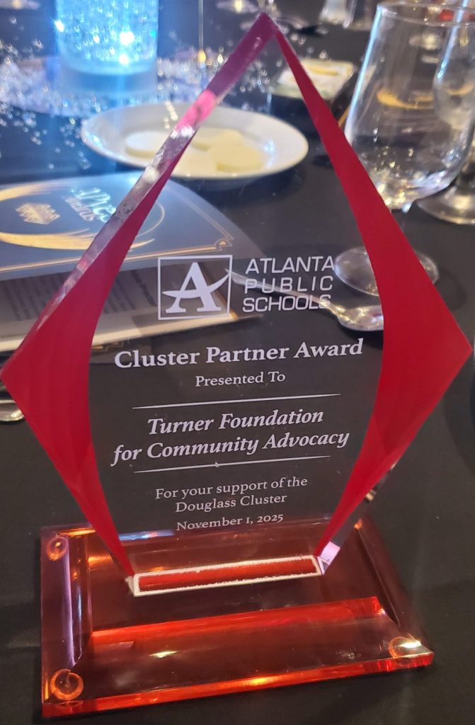 Red glass award for Turner Foundation, presented by Atlanta Public Schools for community advocacy, on a banquet table.